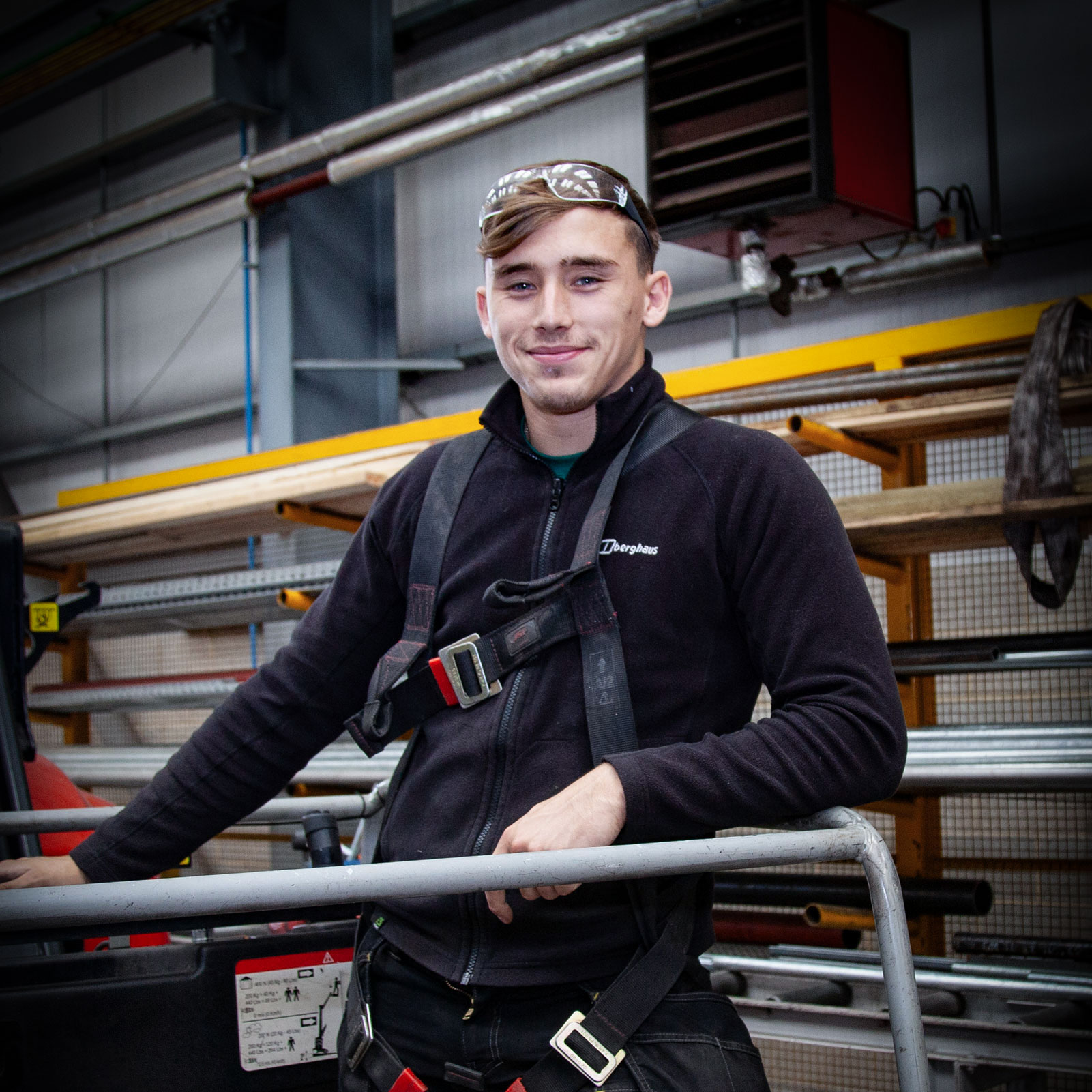 Man on a scissor lift smiling at the camera